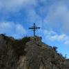 Cruz de hierro en la ladera E, a pie de carretera.
