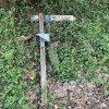 Poste direccional tumbado en el entronque con la carretera